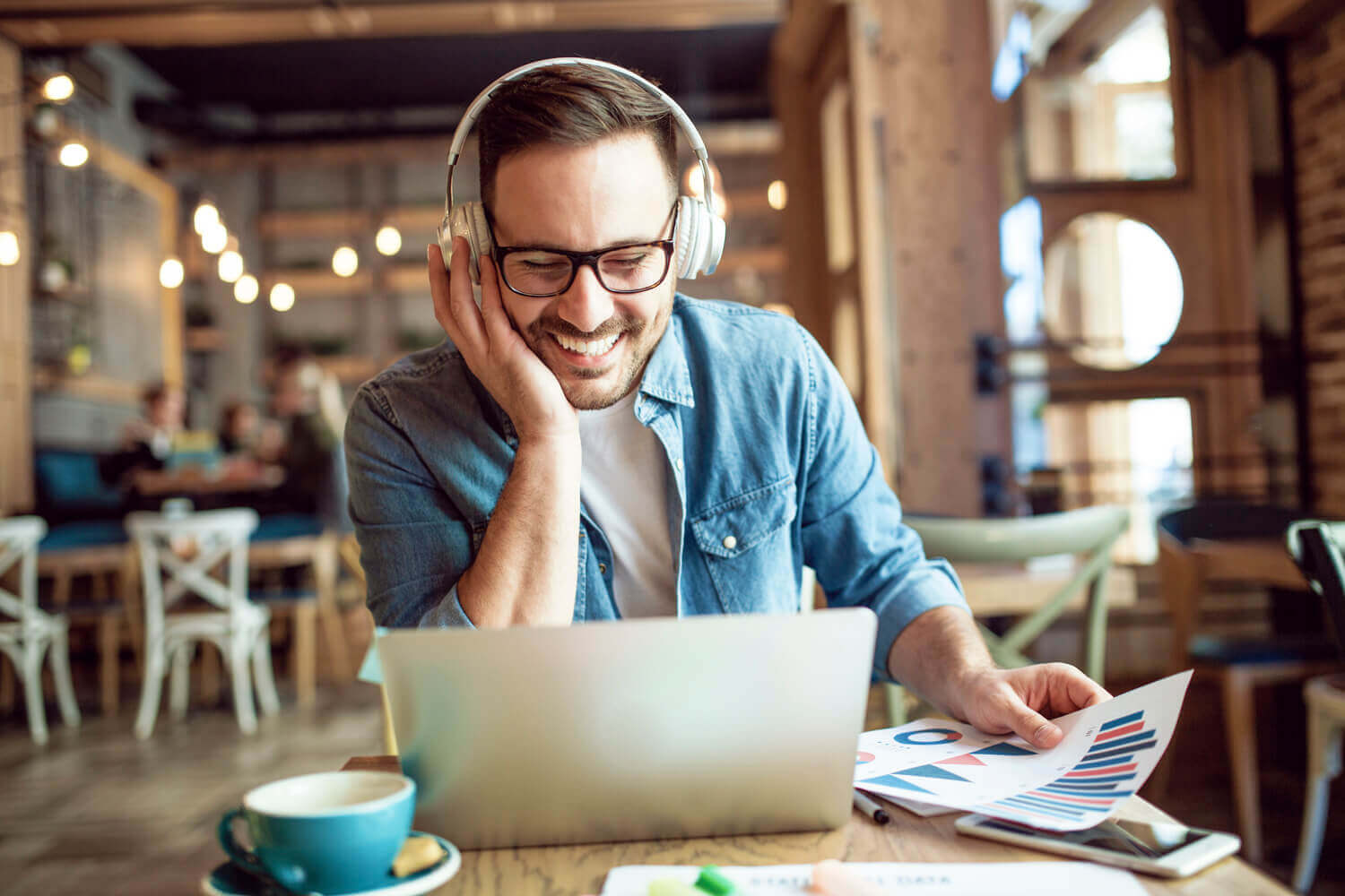 a man viewing a laptop with headphones on