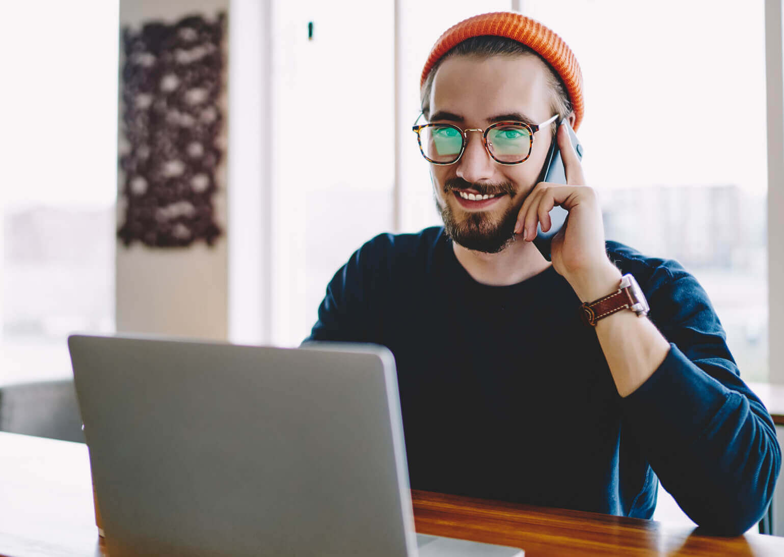 a man on the phone working on a laptop